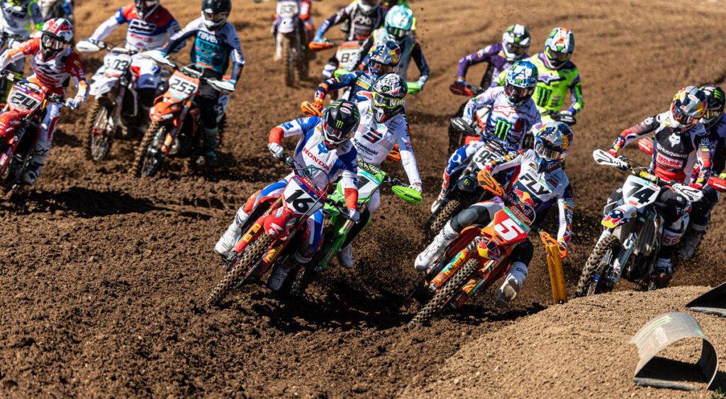 Пелотон MXGP входит в первый поворот, а Лукас Коенен и Том Виалле заметны в группе лидеров.